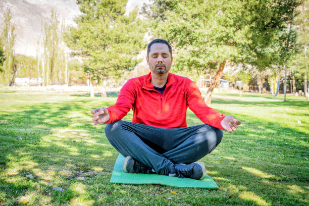 istock latin man meditating in the sunny park 1340814045