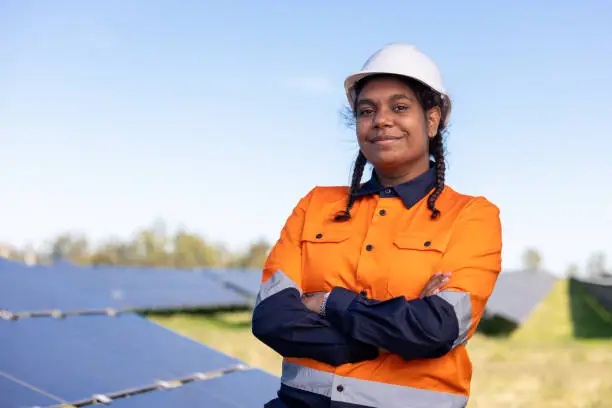 Portrait Of Female Aboriginal Australian Worker On Solar Farm wearing Hi-Vis Workwear