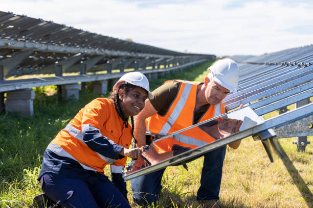 senior engineer und australischer aborigine-auszubildender arbeiten gemeinsam an der installation einer solarfarm - auszubildender stock-fotos und bilder