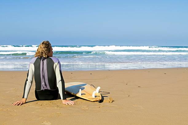 istock Surfer with his surfboard at the beach 134081756