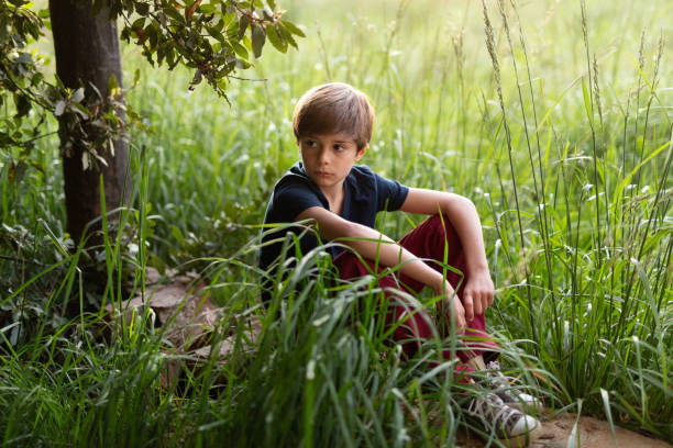 istock 10 years old boy sitting at an uncultivated land 1340820187