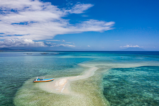 Aerial landscape taken by drone of Gili Putih Suberkima, a unique beach island surrounded by coral reef and located on the northern coast of Bali in Indonesia.