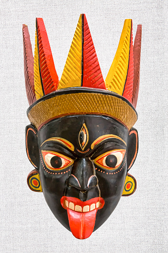 New Delhi, India, January 15th 2019: Tribal Face mask of Hindu Goddess Kali built by the unknown village artist of West Bengal state in India using natural earth colours displayed in white background