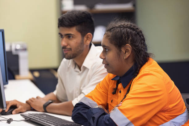 Engineer and Apprentice Working Together In Office stock photo