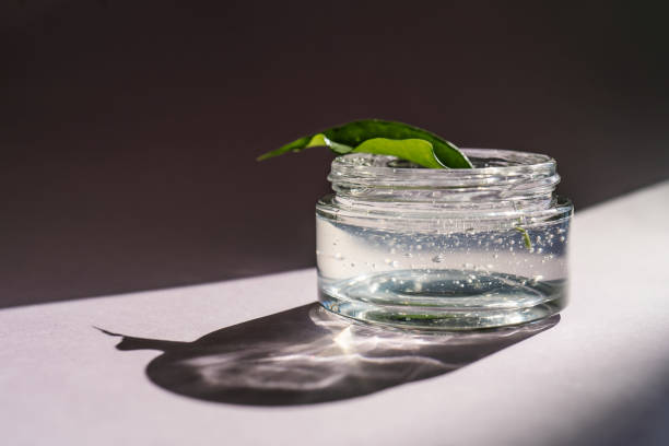 istock Transparent gel in a jar on a lilac background. 1340829252