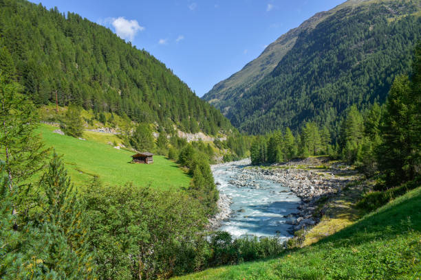 River running through green Alps valley landscape stock photo
