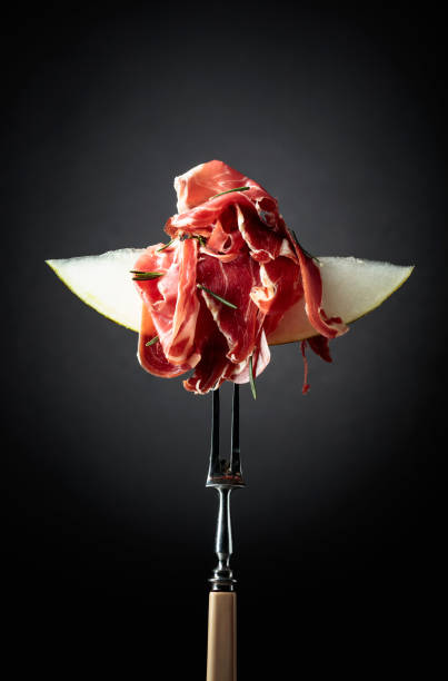 istock Melon with prosciutto and rosemary on a black background. 1340839054
