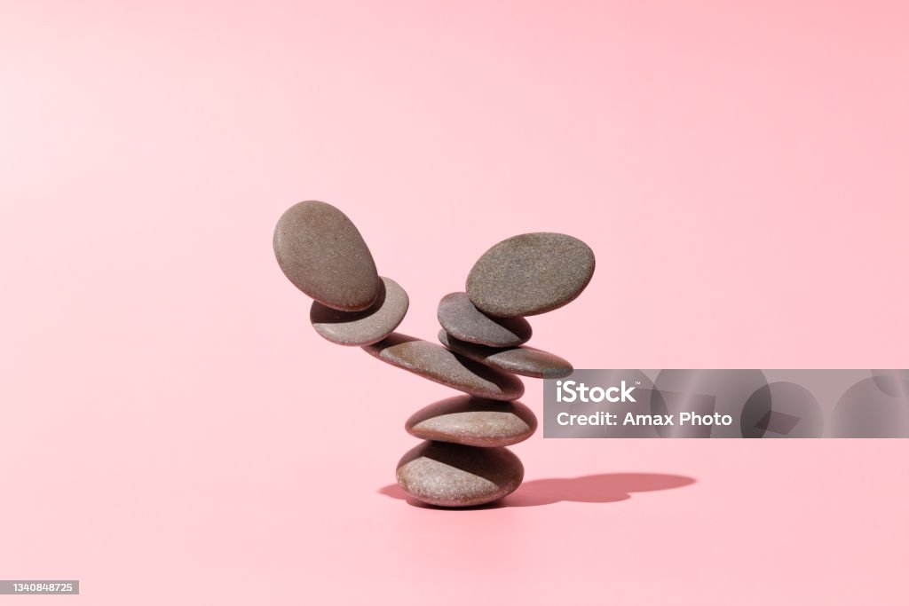 Concept of balance of gray stones on a pink background Balance Stock Photo