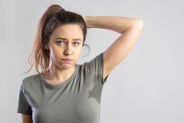 Young woman with her arm raised with her armpits sweat stock photo