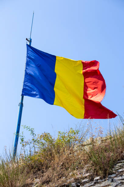 Romanian flag against a blue sky on Cetadea Deva, Transylvania