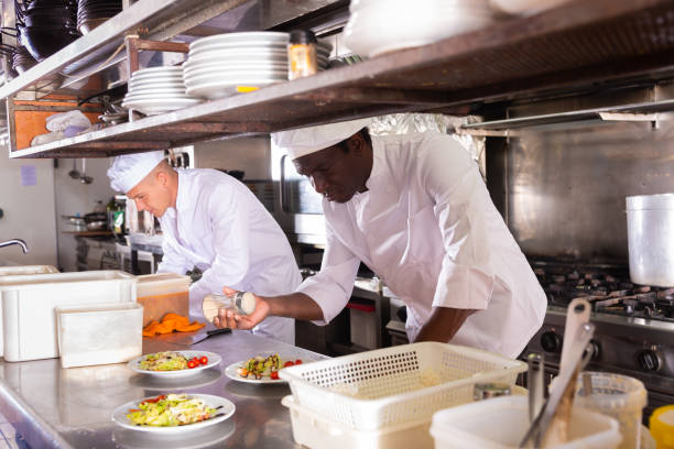 istock Experienced aframerican chef working in professional kitchen of restaurant 1340850946