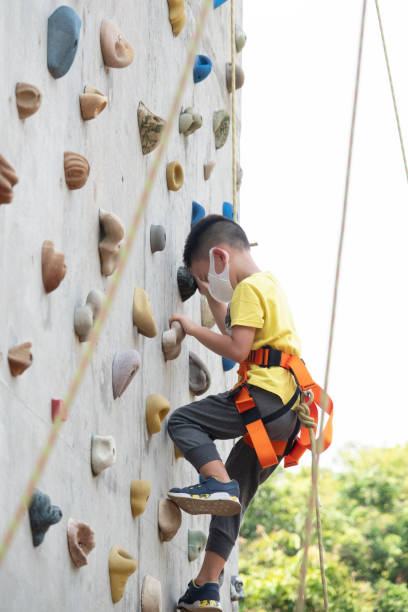 Low Angle View Of Girl Climbing On Artificial Rock