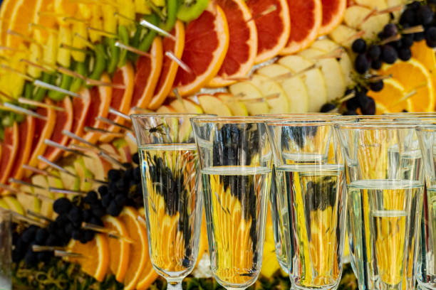 Champagne in glasses on a background of various sliced fruit stock photo