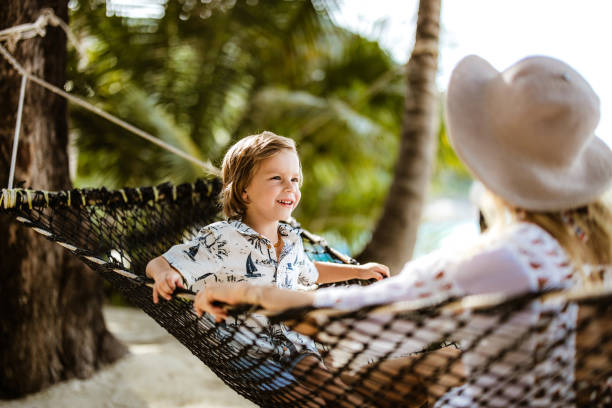 istock Happy boy relaxing with his mother in a hammock on the beach. 1340854752