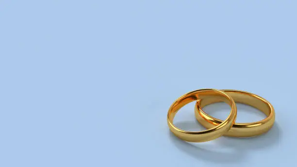 Two wedding gold rings lie on each other with blank space background for text. Format 16x9. 3d rendering