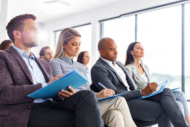 istock Large group of entrepreneurs taking notes on a seminar in board room. 1340856093