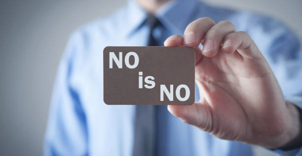 istock Man showing No Is No text on wooden board. 1340859385
