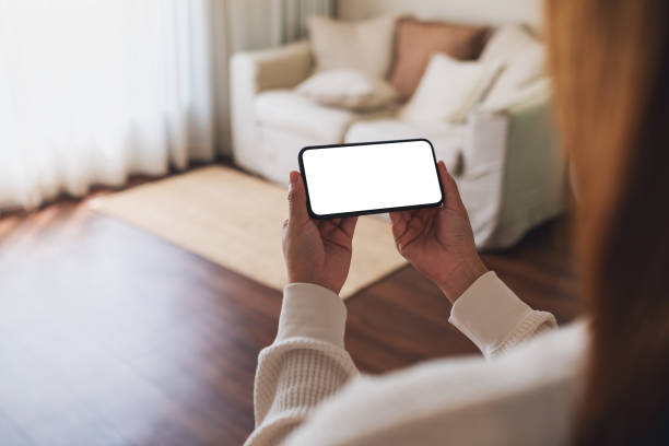 istock A woman holding mobile phone with blank desktop white screen at home 1340861123