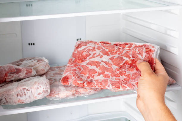 istock Man taking out frozen meat from freezer. 1340863361