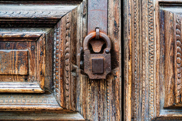istock Old rusty padlock on an old wooden door close-up. Horizontal frame 1340864990
