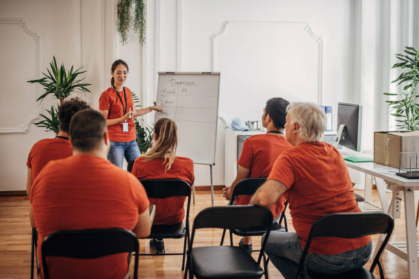 Team of volunteers having a meeting about plans and target for donations Team of volunteers having a meeting about plans and target for donations non profit organization stock pictures, royalty-free photos & images