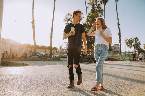 Generation Z couple enjoying a drink at sunset in Santa Monica.