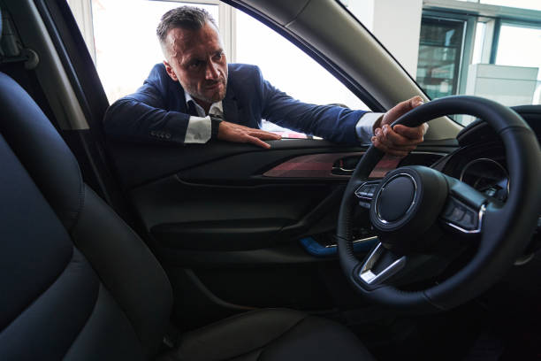 istock Serious customer looking at the car of his dream 1340868910