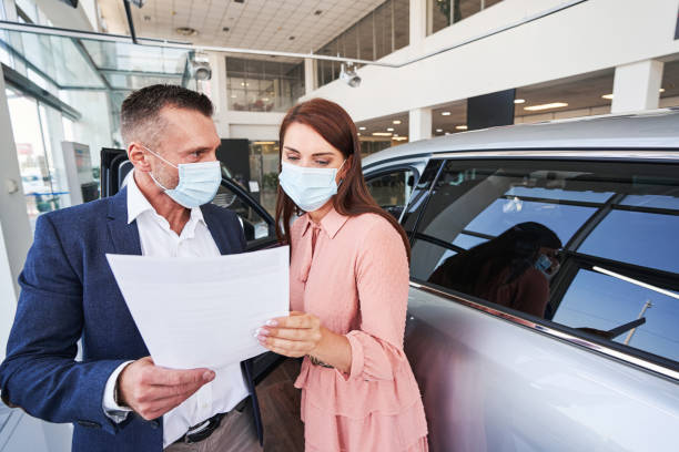 istock Reading the documents in car dealership before the purchase 1340868941
