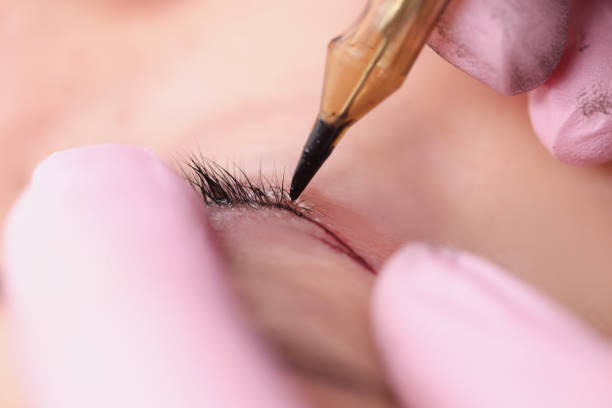 istock Permanent makeup artist making eyelid tattoo for client in beauty salon closeup 1340869084