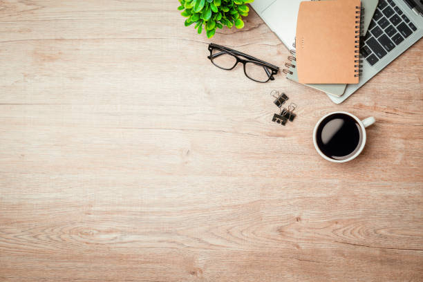 Work from home. desk office with laptop, blank notepad, coffee cup and pen on wood table. Flat lay top view copy spce.