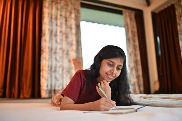 istock Woman writing in a diary lying on a bed 1340871087