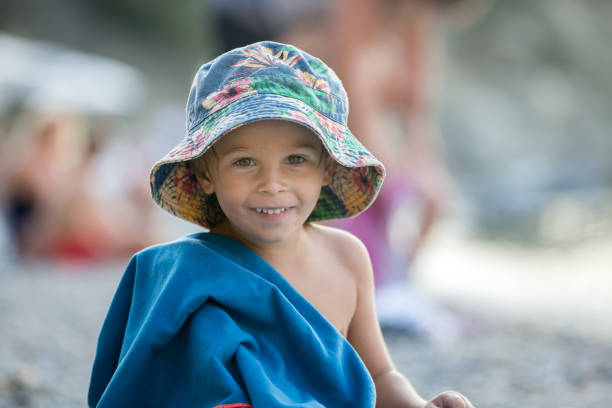istock Cute blond toddler boy, reading a book on the beach 1340871099