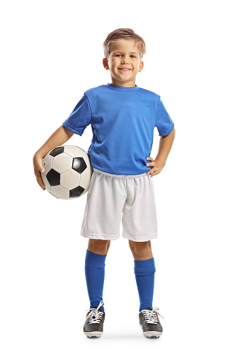 Full length portrait of a happy boy in a football jersey posing with a ball isolated on white background