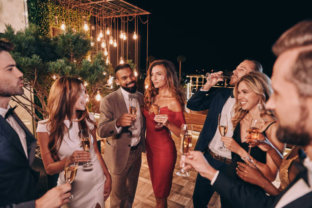 grupo de hermosas jóvenes en ropa formal comunicándose y sonriendo - vestido de noche fotografías e imágenes de stock