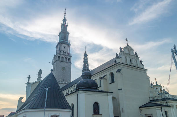 les toits du monastère de jasna gora et le beffroi et la tour au coucher du soleil à czestochowa, en pologne. - monastère de jasna góra photos et images de collection