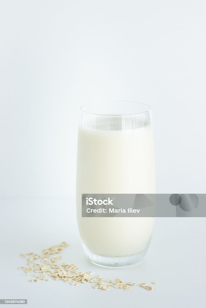 Glass of oat milk on white background Close up of glass of oat milk with oats isolated on white background with copy space; sustainable lifestyle Breakfast Stock Photo