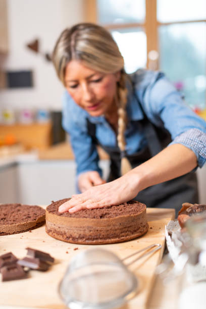 istock Woman baking at home, drip cake preparation, cutting chocolate sponge cake slice with thread rope 1340874181