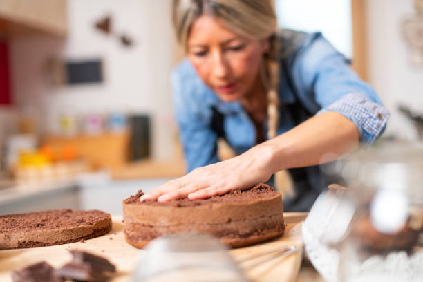 istock Woman baking at home, drip cake preparation, cutting chocolate sponge cake slice with thread rope 1340874194