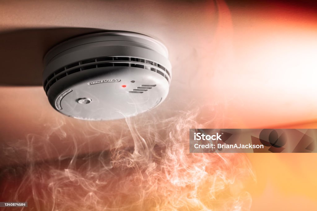 Smoke detector and interlinked fire alarm in action background Smoke detector and interlinked fire alarm in action background with copy space Smoke Detector Stock Photo