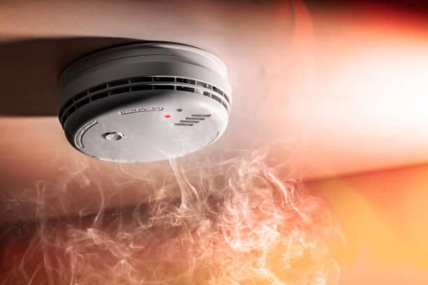 Smoke detector and interlinked fire alarm in action background stock photo
