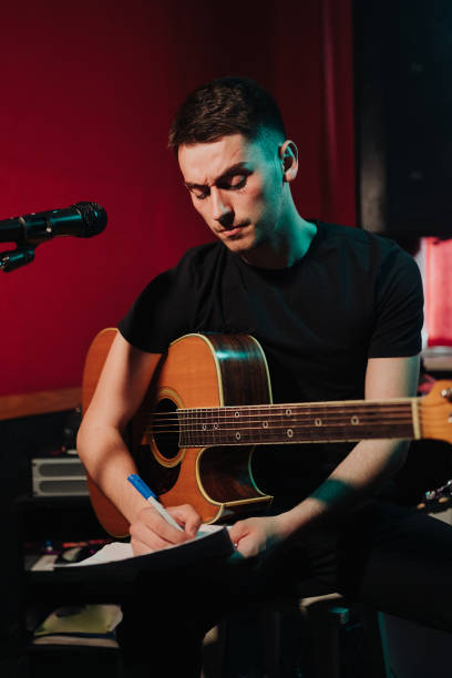 istock Young man with an acoustic guitar writing songs 1340875374