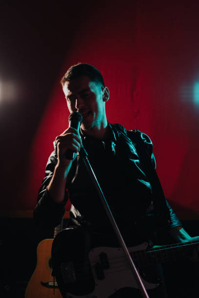 istock Man in leather jacket performing on a dark stage in club 1340875442