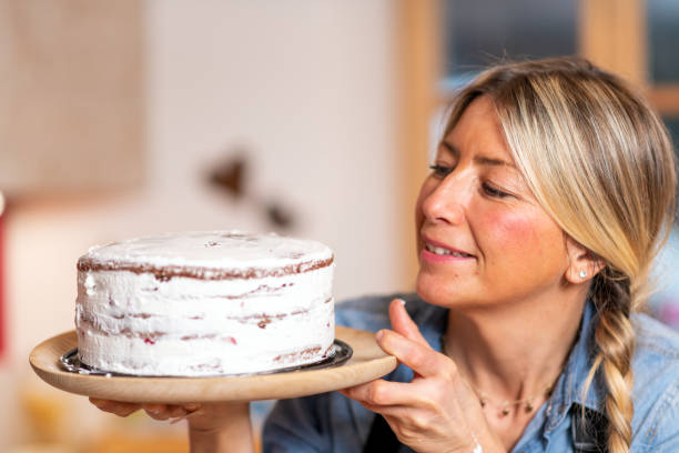 istock Woman baking at home, drip cake preparation: Spreading whipped cream 1340875456