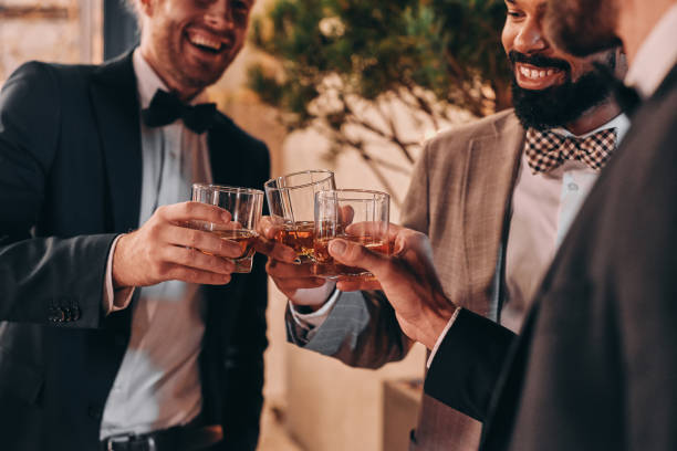 istock Close-up of three well-dressed men drinking whiskey and communicating 1340877328