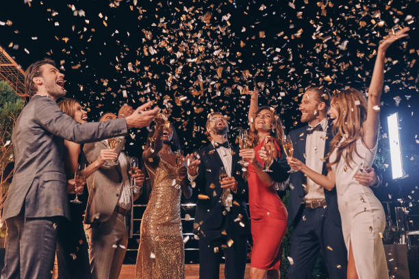 Group of beautiful people in formalwear having fun together Group of beautiful people in formalwear having fun together with confetti flying all around upper class stock pictures, royalty-free photos & images