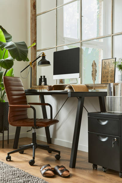 istock Creative composition of modern masculine home office workspace interior with black industrial desk, brown leather armchair, pc and stylish personal accessories. Template. 1340881649