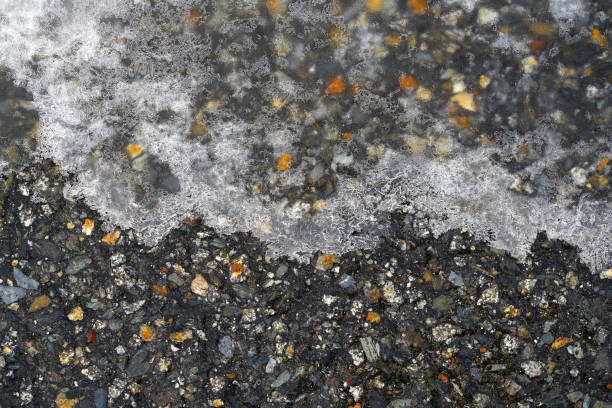 Iced asphalt road pavement detail in winter