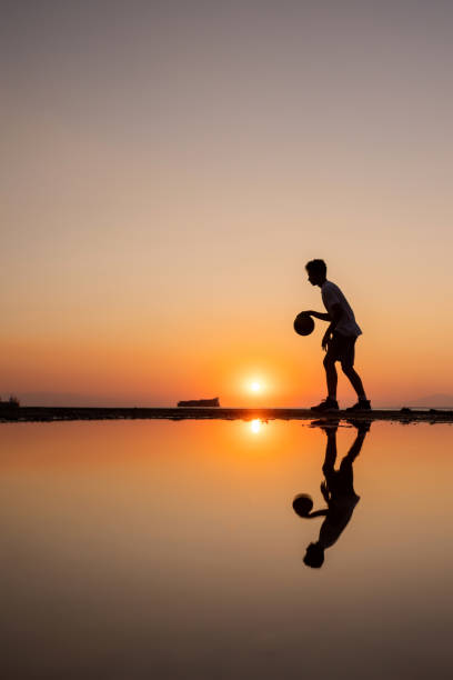 istock Young man practices basketball at sunset 1340883180