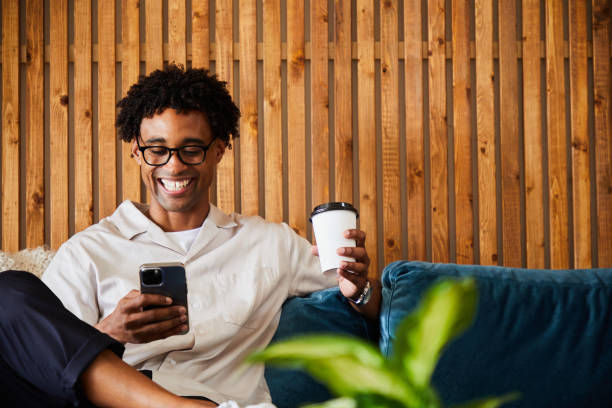 istock Smiling designer checking his phone during an office coffee break 1340884317