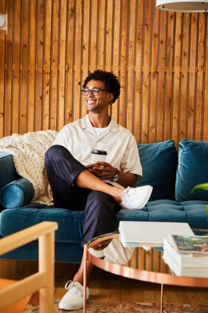 istock Smiling young African American designer drinking coffee during an office break 1340884588
